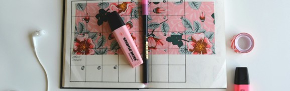 An open monthly calendar surrounded by pens and highlighters, illustrating Medicare enrollment and coverage timing.