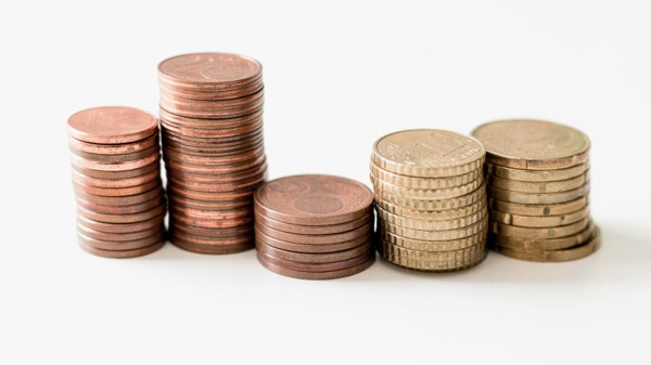 Stacks of coins at different heights, illustrating whole-life cash value accumulated over time.